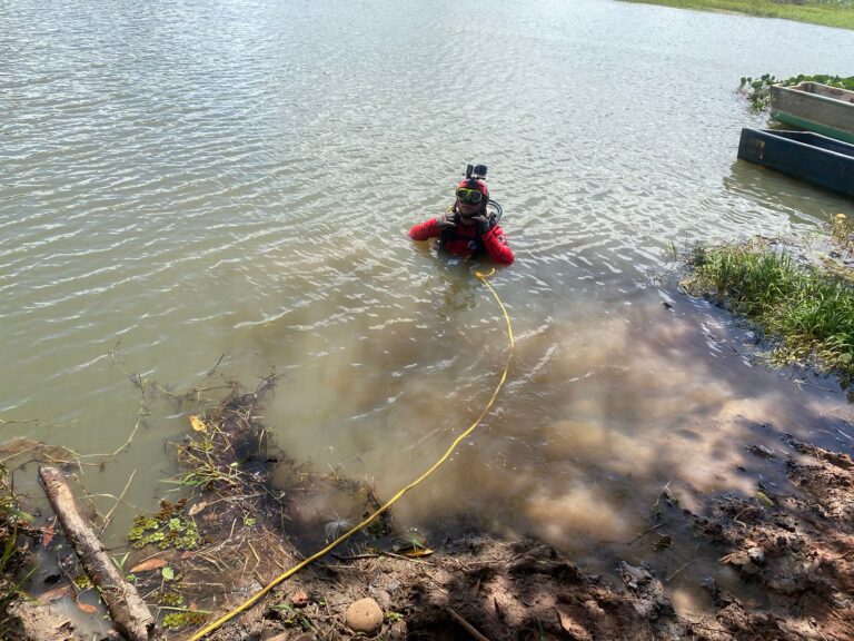 CON BUZOS BUSCAN MUJER Y NIÑA EN RÍO MEDIO QUESO